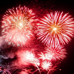 Red and gold fireworks burst in a night sky