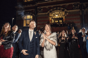 Bride, Groom and guests look up at the sky during a fireworks display for a wedding
